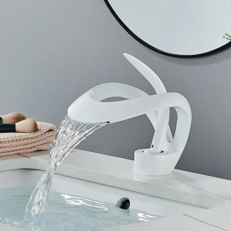 Modern white ceramic basin faucet with sleek sculptural design and waterfall spout for bathroom vanity use