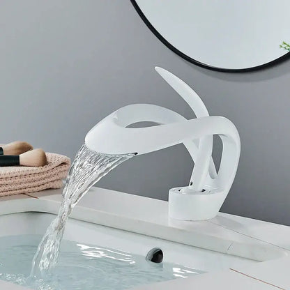Modern white ceramic basin faucet with sleek sculptural design and waterfall spout for bathroom vanity use