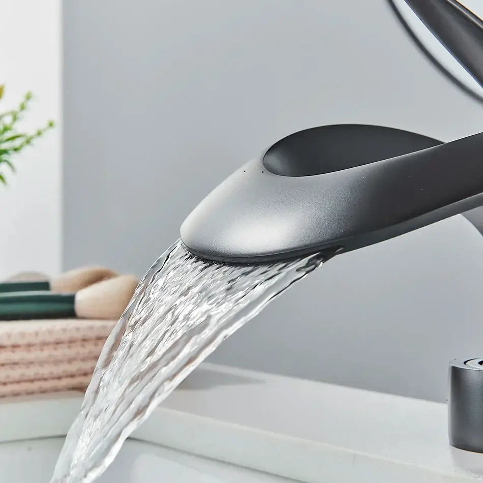 Modern matte black brass waterfall basin faucet with sleek curved design for bathroom vanity use
