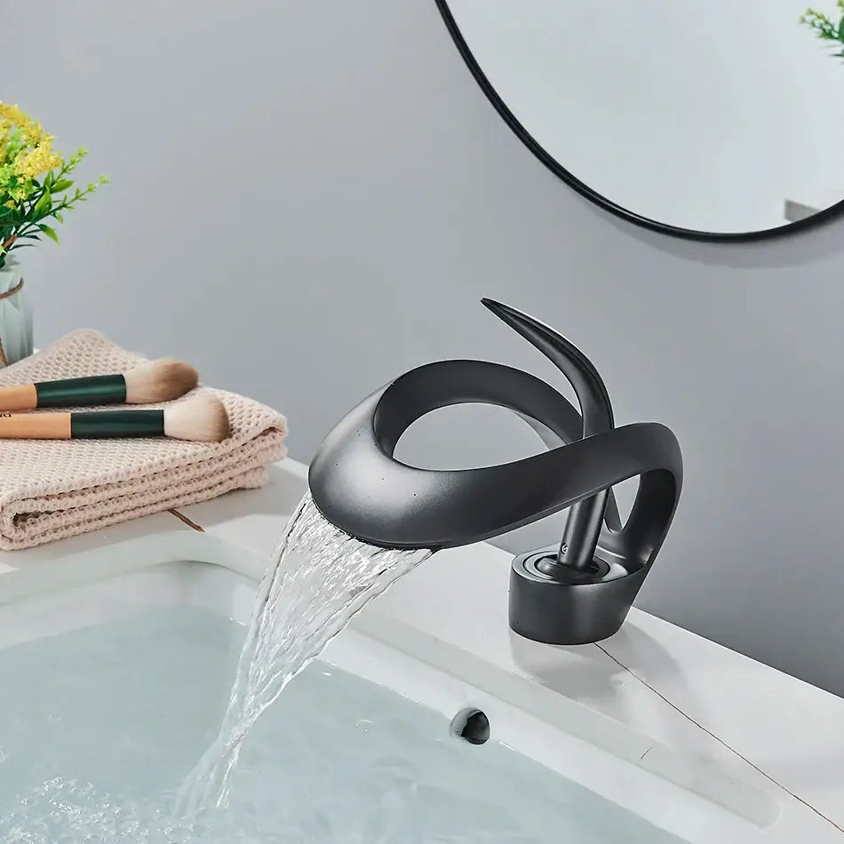 Modern matte black brass waterfall basin faucet with sculpted flowing design for bathroom vanity use