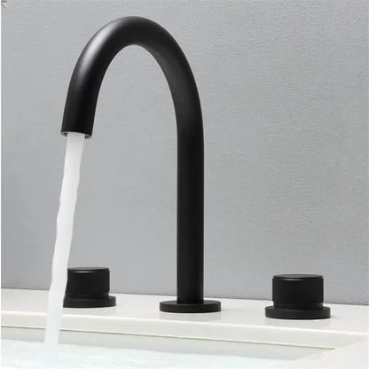Modern matte black basin faucet with curved spout and cylindrical handles in brushed gold basin finish for bathroom sink