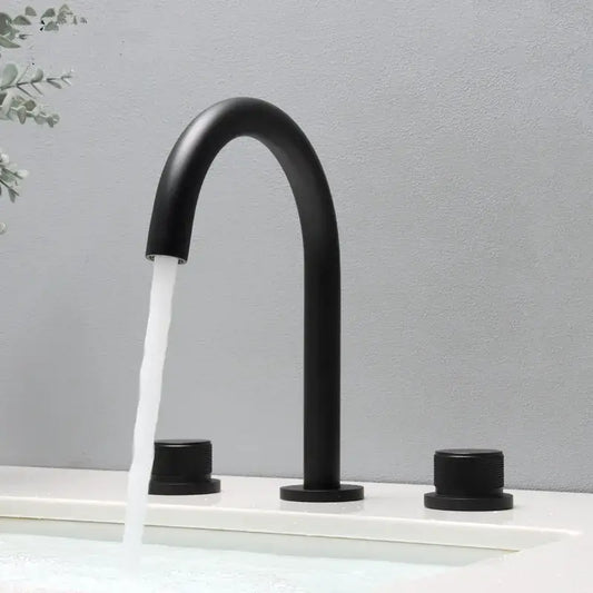 Modern matte black basin faucet with curved spout and two cylindrical handles for brushed gold basin bathroom sink