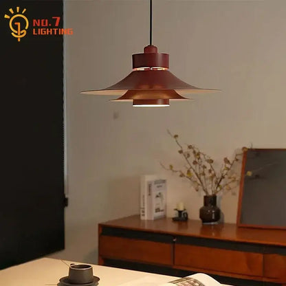 Modern matte black flying saucer pendant light with layered flared design in warm copper finish for dining room decorbites modern flying