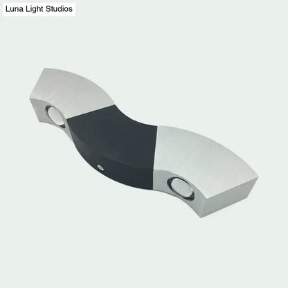 Modern matte black and gray sconce light with silver aluminum wave design and warm white lighting for bedroom use