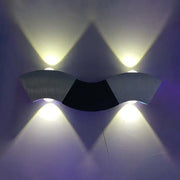 Modern matte black and gray sconce light with aluminum wave design featuring warm white lighting and a sleek curved form