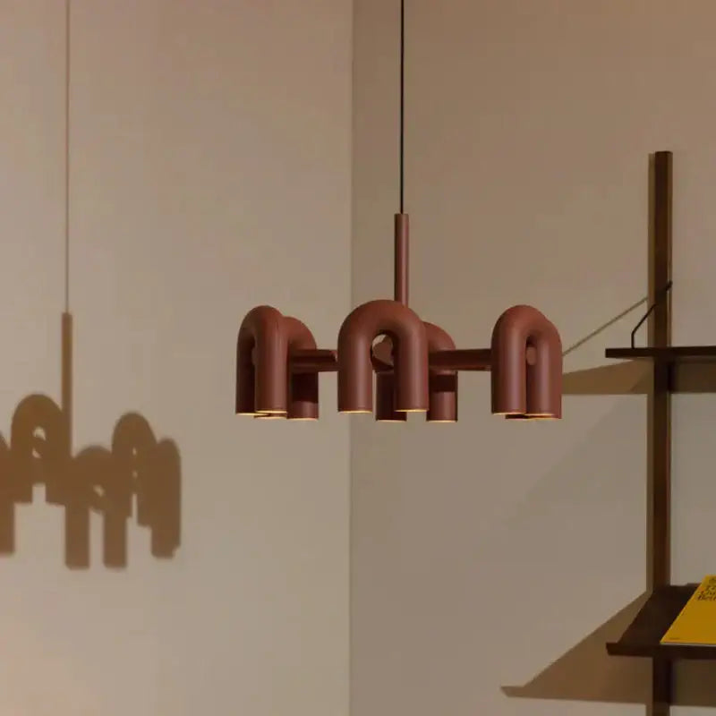 Modern terracotta-colored pendant light with sleek u-shaped metal design complementing wall lamp decorbites cirkus tube