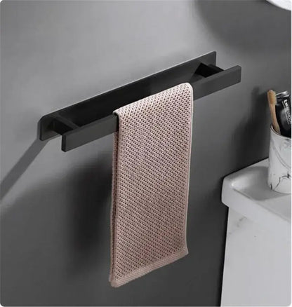 A sleek matte black steel towel rack holds a soft blush pink microfiber hand towel for modern bathroom decorbites towel hanger