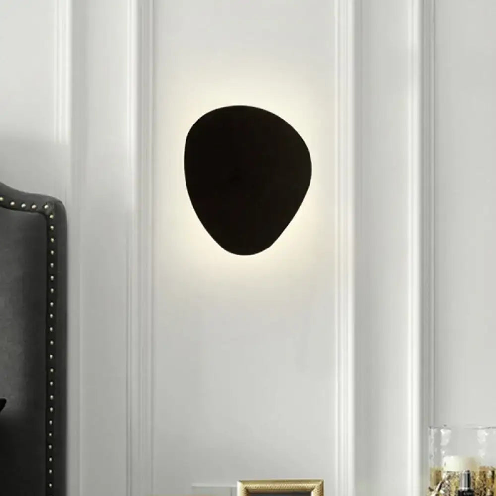 Modern matte black triangle wall lamp with irregular shape and soft glow designed for corridor lighting