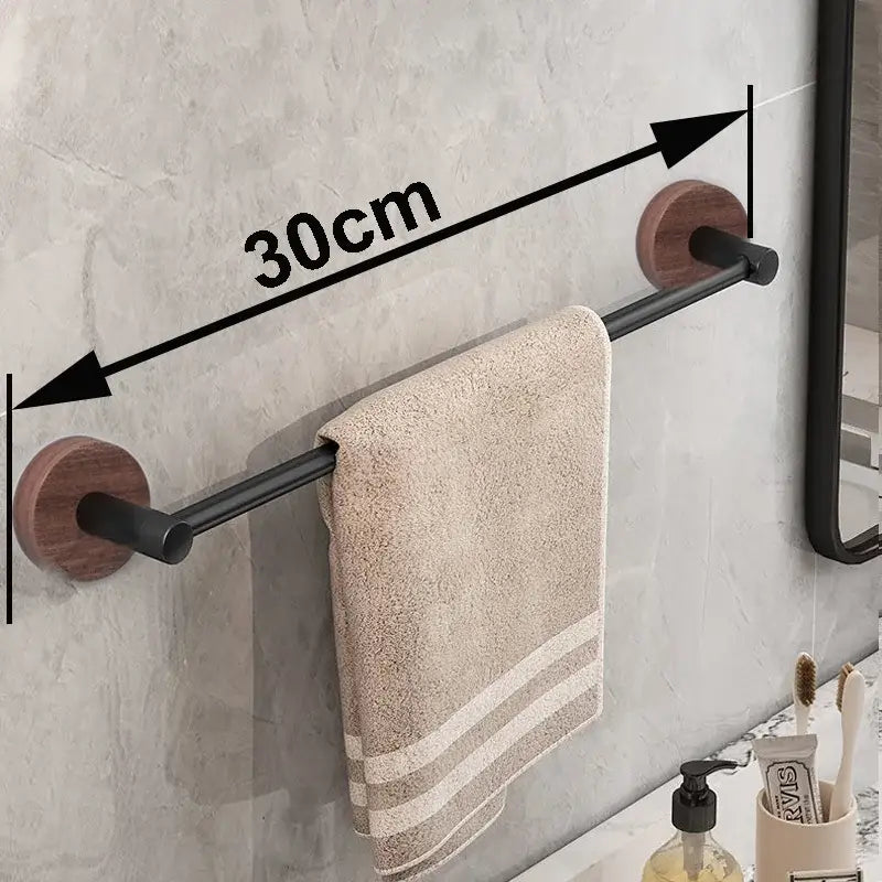 Modern matte black wall mounted towel bar with wood accents holding a beige textured towel in bathroom setting