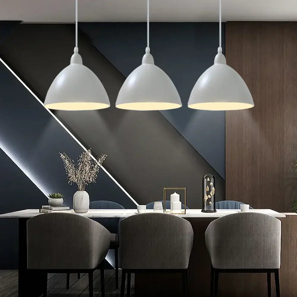 Three white matte dome-shaped decorbites colorful nordic pendant lights hanging above a dining table