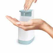 A sleek modern automatic soap pump dispenser with matte white body and teal accents for kitchen space saving