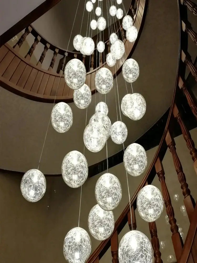 A modern decorbites crystal ceiling chandelier with spherical glass orbs and delicate wire mesh emitting soft white light