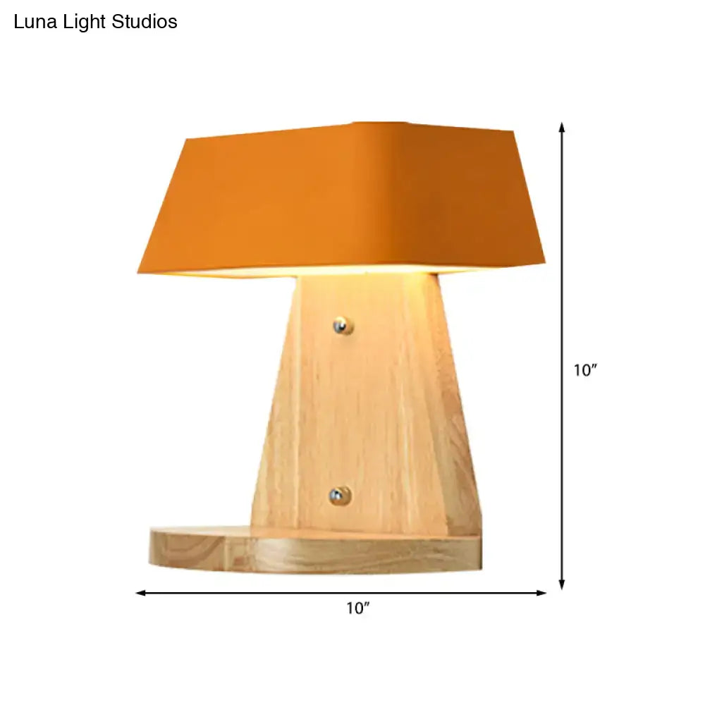 A modern metal trapezoid wall sconce with a wooden backplate and a warm orange fabric shade light fixture