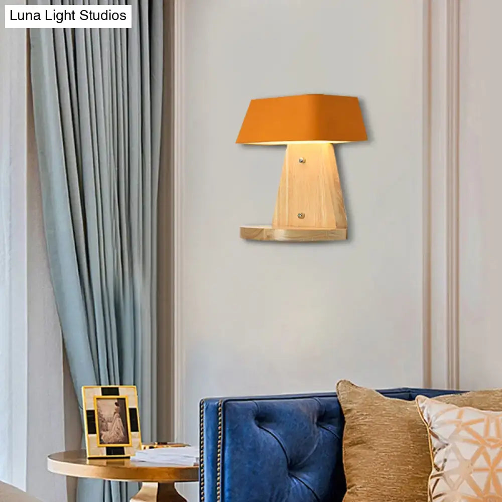 Modern metal light fixture with orange fabric lampshade mounted on wooden backplate with integrated shelf for living room