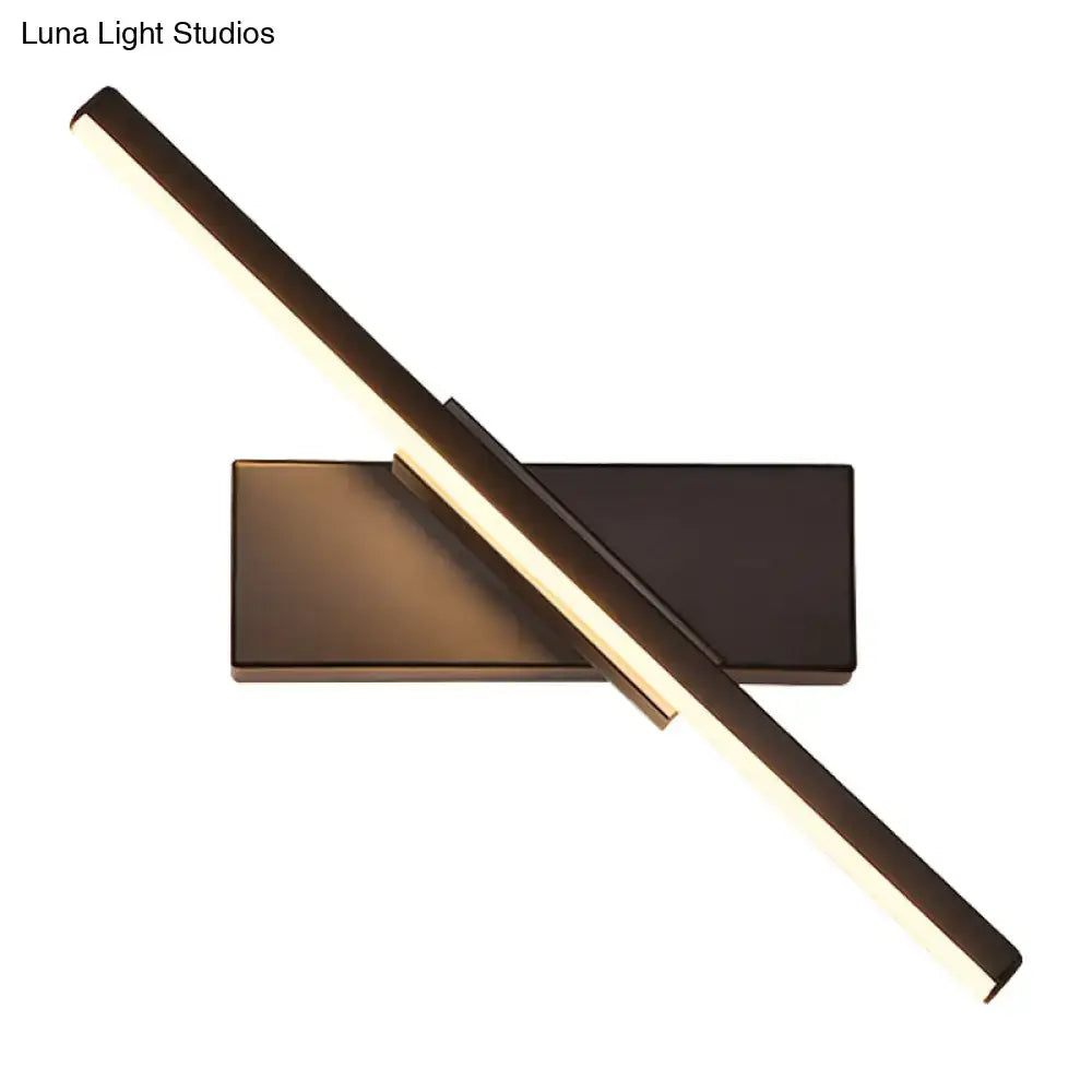Modern metallic black linear vanity wall sconce with two intersecting led bars emitting a warm glow