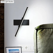 Modern metallic black linear vanity wall sconce with a sleek angular design and slim profile for bathroom lighting