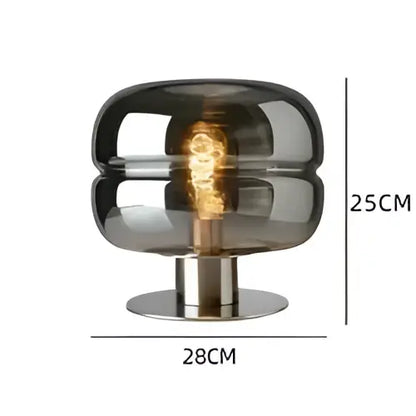 A modern metallic glass table lamp with a smoked glass dome and brushed metal base for elegant bedroom table lighting