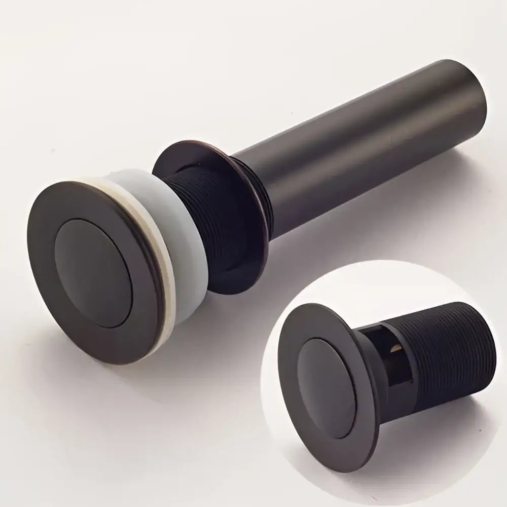 Modern metallic pop up bathroom basin waste in black matte finish with sleek cylindrical design and push-button mechanism
