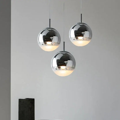Modern metallic tri color ball pendant lights with sleek chrome finish and warm glowing interiors for living room