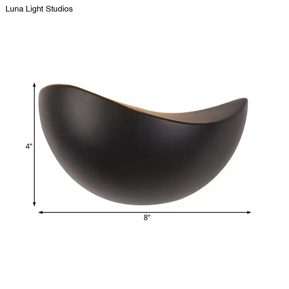 A sleek matte black ceramic bowl with a crescent shape used in modern metallic wall washer bedroom sconce lighting