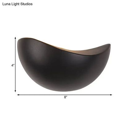 A sleek matte black ceramic bowl with a crescent shape used in modern metallic wall washer bedroom sconce lighting