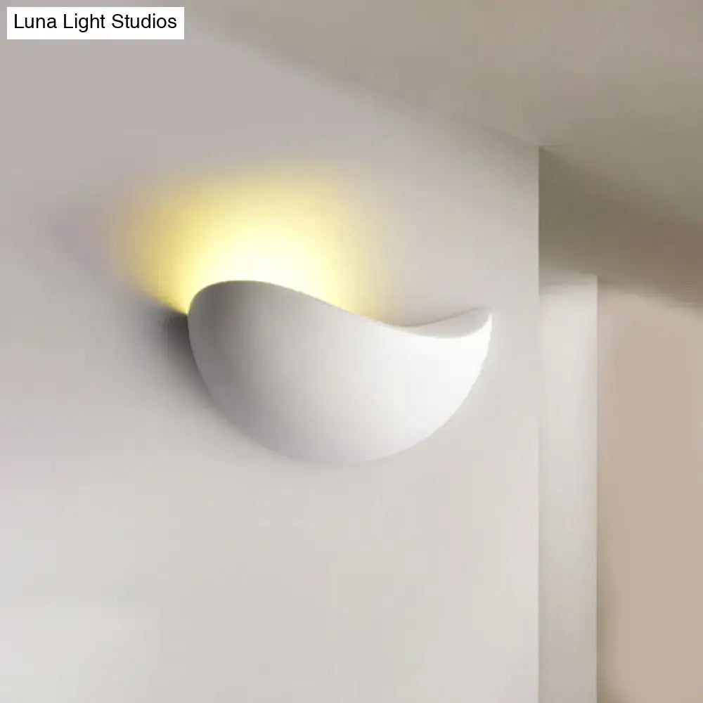 White ceramic wall sconce with smooth curved design and warm light for modern metallic wall washer bedroom use