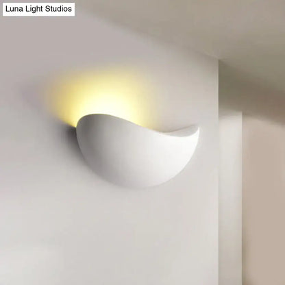 White ceramic wall sconce with smooth curved design and warm light for modern metallic wall washer bedroom use