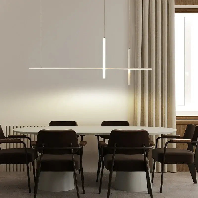 Minimalist white oval dining table with dark wooden chairs illuminated by modern decorbites dimmable led pendant lights