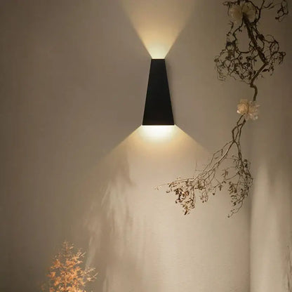 Black minimalist led wall lamp with sleek angular design casting warm focused light for bedroom reading
