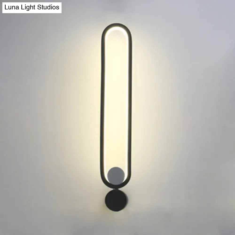 Modern minimalist black led wall sconce with sleek oval design providing warm ambient lighting for bedroom and living room