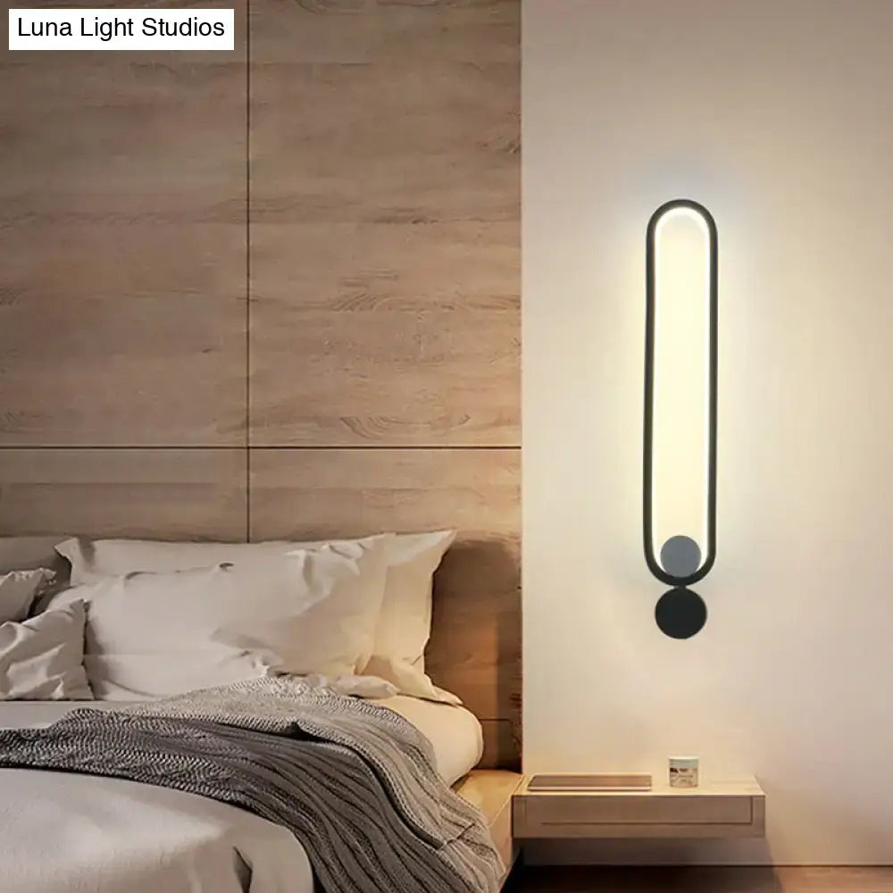 Modern minimalist black led wall sconce with sleek oval design providing warm ambient lighting for bedroom and living room