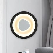 Modern minimalist black wall light with acrylic shade featuring a glowing warm white ring and irregular mirror for bedroom