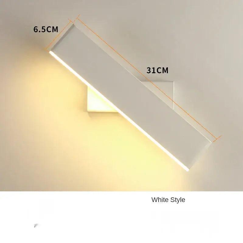 A sleek white rectangular wall lamp with a modern design and warm glow for bedroom bedside reading