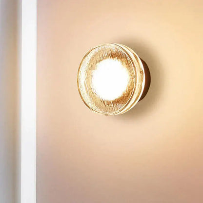 Modern minimalist black wall lamp with frosted glass and a warm textured golden finish for luxury bathroom decorbites light