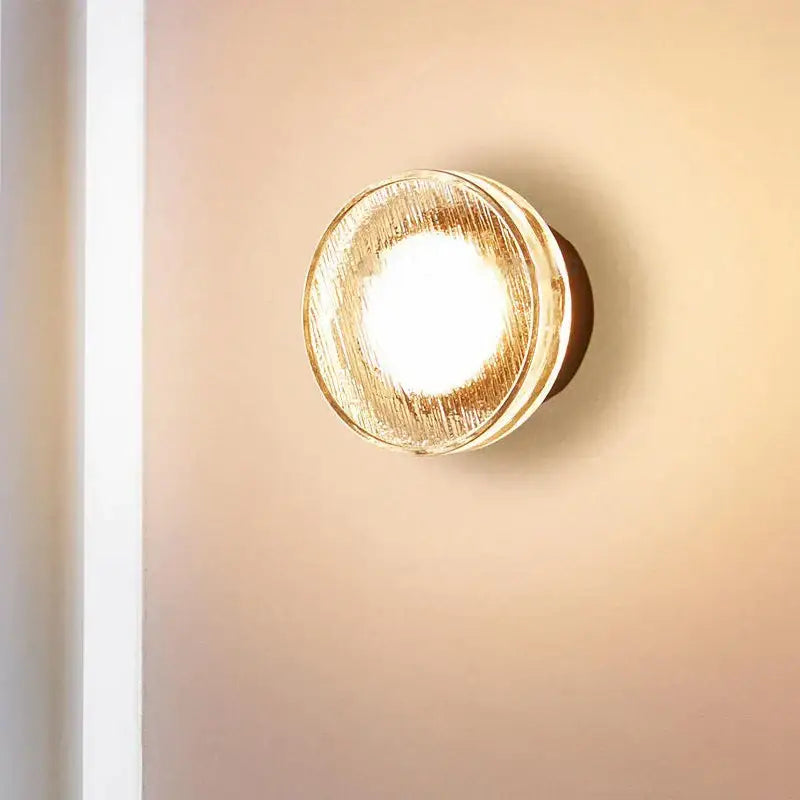 Modern minimalist black wall lamp with frosted glass and a warm textured golden finish for luxury bathroom decorbites light
