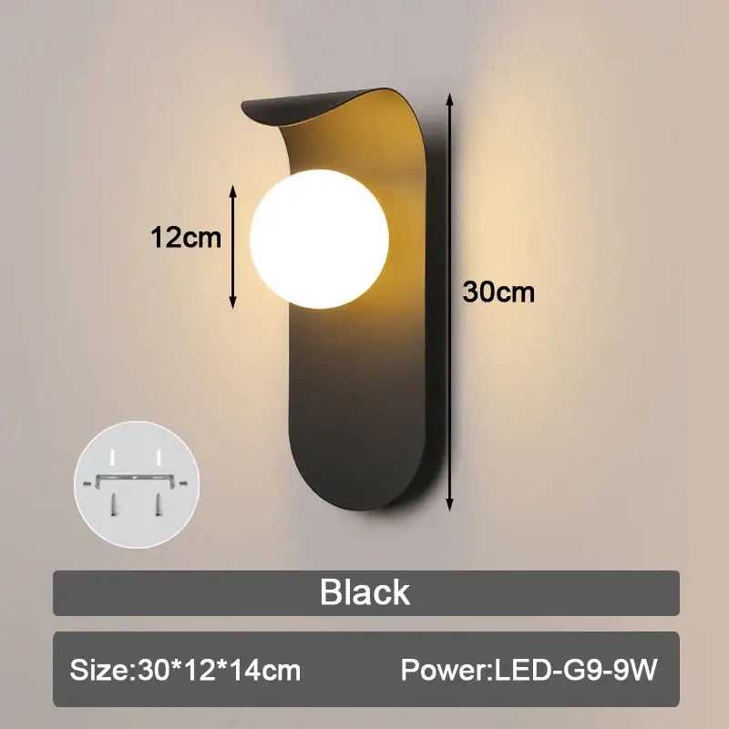 Modern minimalist black led wall lamp with a sleek curved metal body and frosted glass ball shade for bedroom use