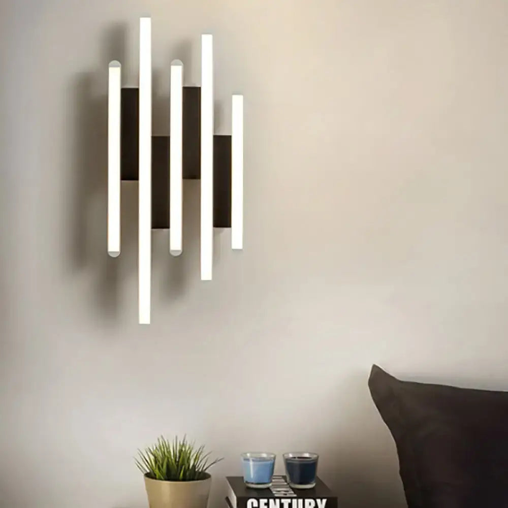 Modern minimalist black and white led wall sconce with five vertical bars alternating warm white light and matte black