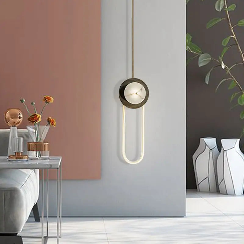 Modern minimalist bronze and white oval wall lamp with sleek curved arm and dark bronze fixture for bedroom lighting