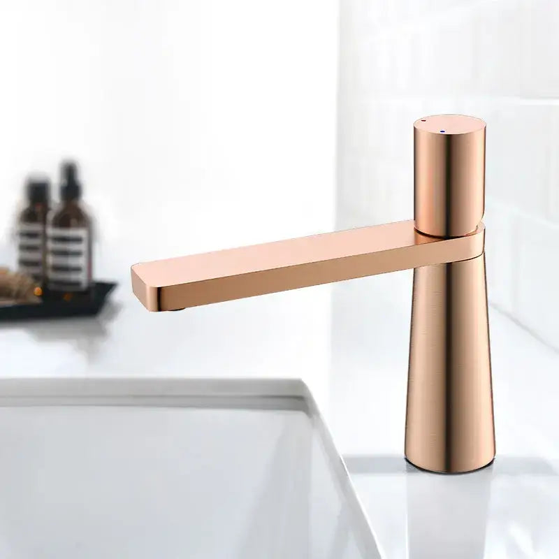 Modern minimalist basin faucet in rose gold with brushed gold finish and sleek decorbites brushed gold design