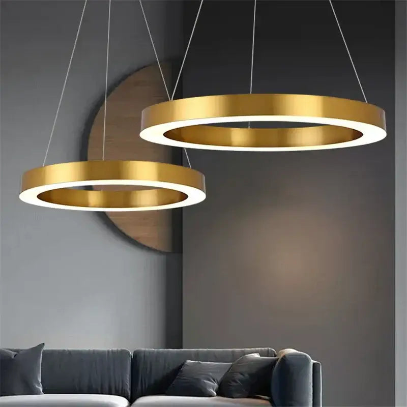 Two modern minimalist circular gold ring pendant lights with illuminated inner rings for dining room decorbites circular gold