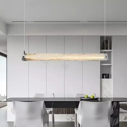 A modern minimalist cloud fog glass pendant light with natural wood finish and metallic ends hangs above dining table