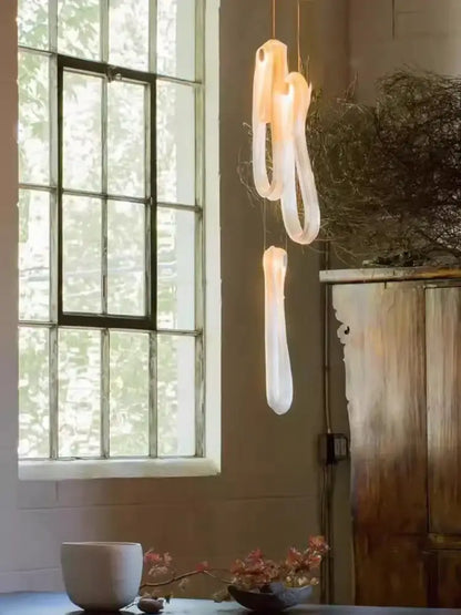 A modern minimalist elegant led glass chandelier with translucent white organic shapes for dining room lighting
