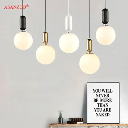 Modern minimalist pendant lamp with spherical frosted glass ball led shades and black and gold metallic fixtures for decorbites