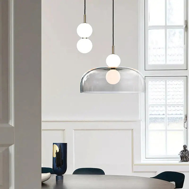 Modern minimalist pendant light featuring frosted glass ball spheres and a transparent dome shade for living room decorbites glass ball