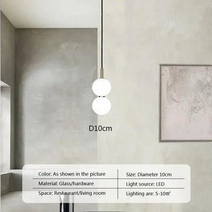 Modern minimalist pendant light with two frosted glass ball spheres on a slender brass rod for living room decorbites