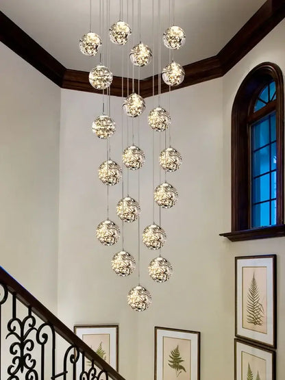 A modern minimalist gold decorbites glass chandelier with multiple faceted spherical glass orbs for staircase lighting