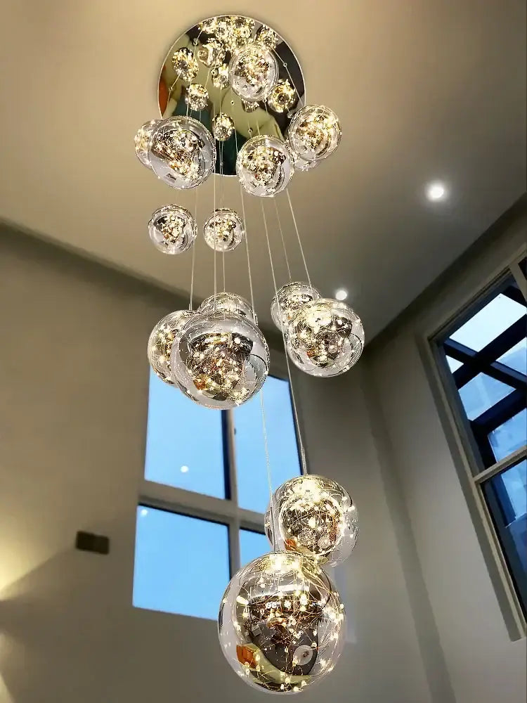 Modern minimalist gold decorbites glass chandelier with multiple clear glass spheres and warm led lights for staircase lighting