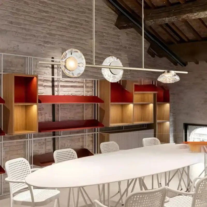 Modern minimalist gold glass led chandelier with clear textured glass shades and sleek metallic frames above white table