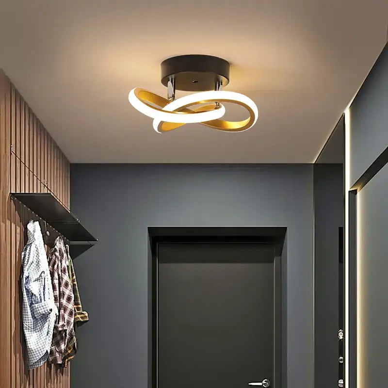 Modern minimalist gold led ceiling light with two interlocking rings and black base emitting warm white decorbites led ceiling illumination