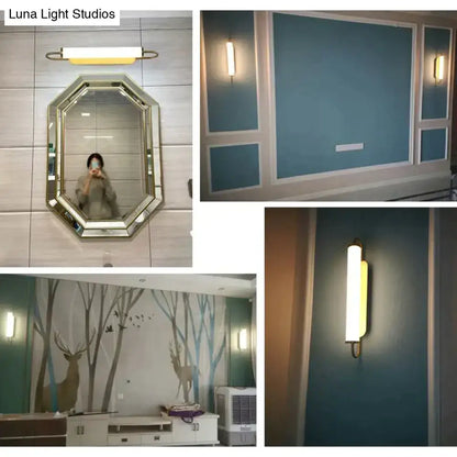 A sleek cylindrical led wall lamp with brass finish and warm yellow diffuser for modern minimalist bedroom use